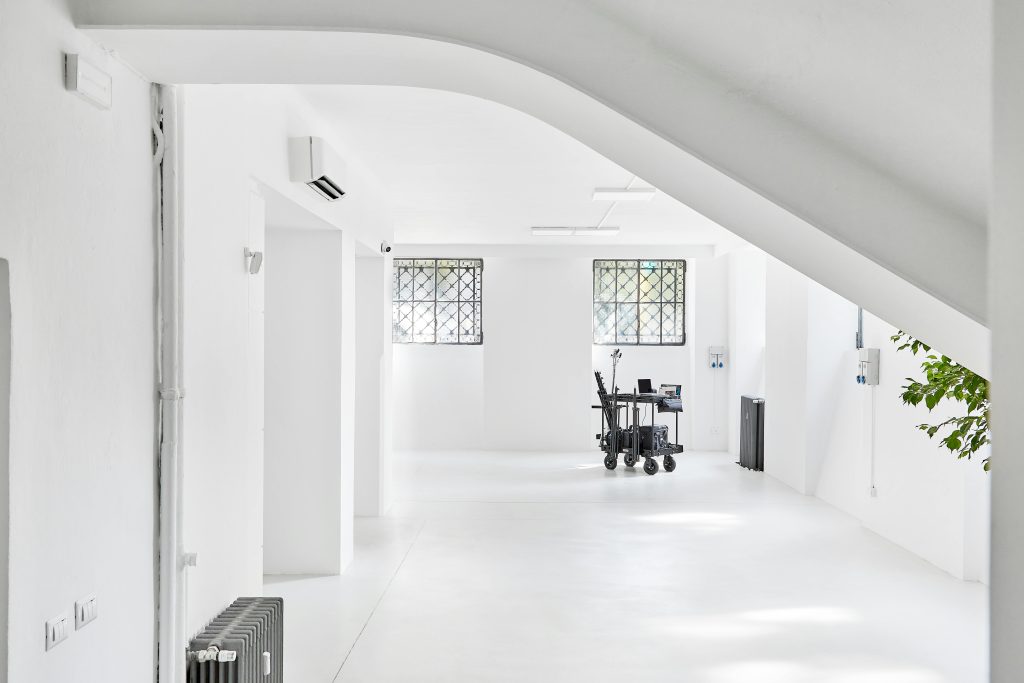 Bright minimalist interior space with white walls and modern equipment cart.