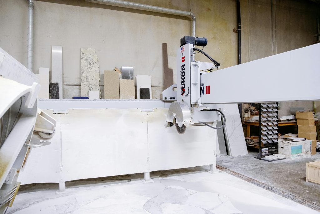 High-tech machine in a factory cutting granite slabs. Industrial setting.