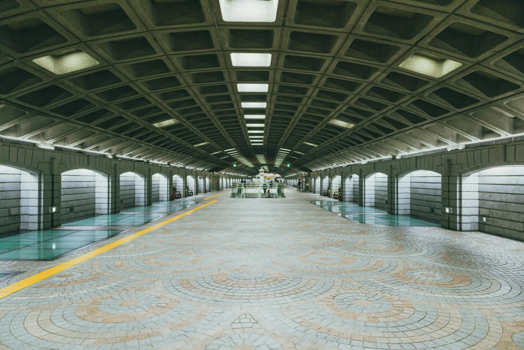Wide view of a modern and symmetrical subway station in Seoul, South Korea.