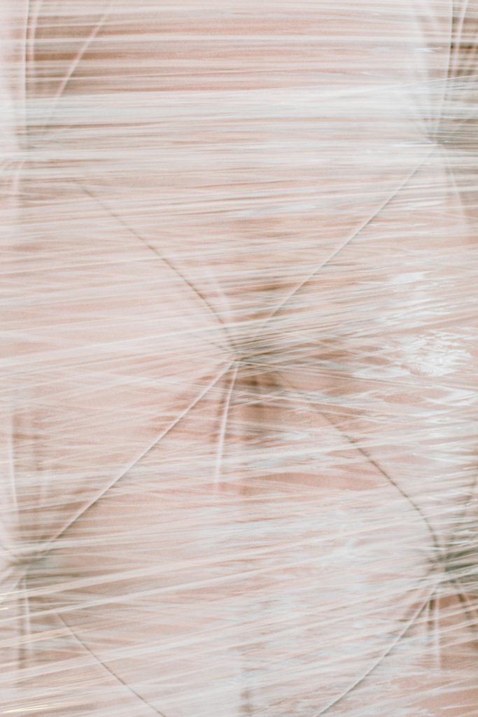 Close-up of a sofa wrapped in plastic, ideal for moving or protection.