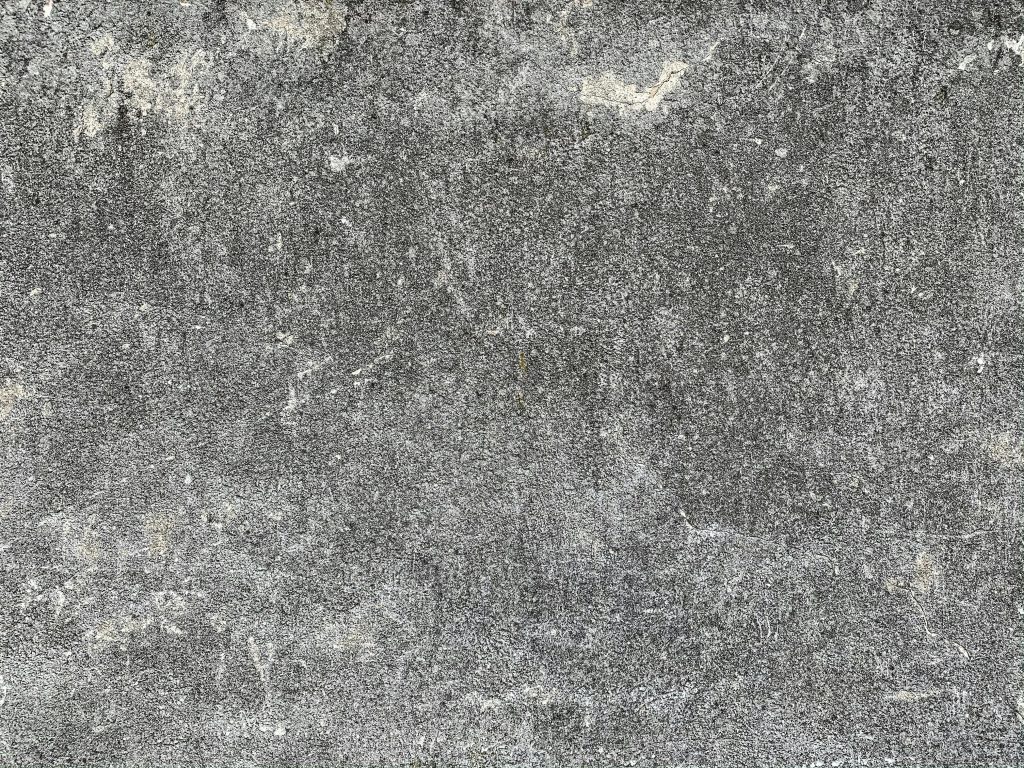 Close-up of a gray concrete wall showcasing rough texture and detailed surface patterns.