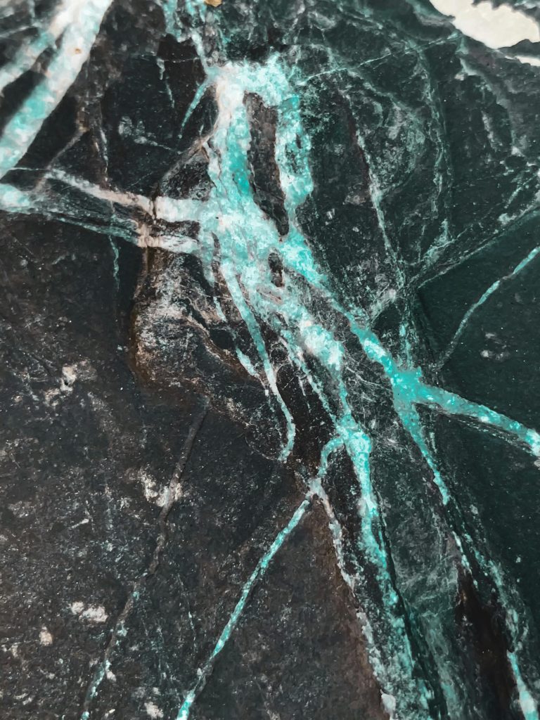 Textures surface of old shabby black stone with blue lines cracks and scratches