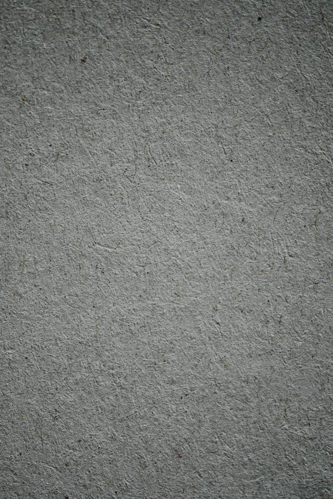 A vertical shot of a textured gray concrete surface, ideal for background use.